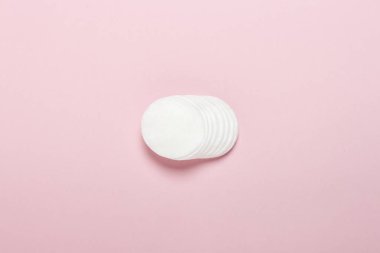 Pembe bir arka plan üzerinde makyaj için pamuk hijyenik diskler. Makyaj ve hijyen konsepti. Düz döşeme, üst görünüm