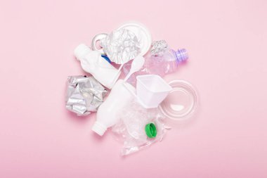 Çöp toplama, plastik ve metal pembe bir arka plan üzerinde. Kavram durdurmak plastik, geri dönüşüm, çöp ayrı toplama. Düz döşeme, üst görünüm