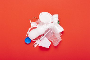 Kırmızı arka planda plastik atık toplama. Kavram plastik geri dönüşüm çöp durdurmak. Düz döşeme, üst görünüm