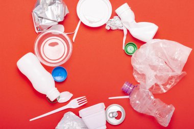 Kırmızı arka planda plastik ve tin atık toplama. Kavram durdurmak plastik, geri dönüşüm, çöp ayrı toplama. Düz döşeme, üst görünüm