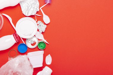 Çöp toplama, plastik ve metal kırmızı bir arka plan üzerinde. Kavram durdurmak plastik, geri dönüşüm, çöp ayrı toplama. Düz döşeme, üst görünüm