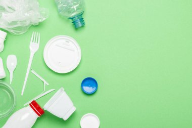 Çöp toplama, yeşil arka plan üzerine plastik. Kavram durdurmak plastik, geri dönüşüm, çöp ayrı toplama. Düz döşeme, üst görünüm