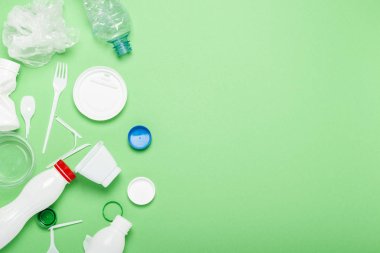 Çöp toplama, yeşil arka plan üzerine plastik. Kavram durdurmak plastik, geri dönüşüm, çöp ayrı toplama. Düz döşeme, üst görünüm