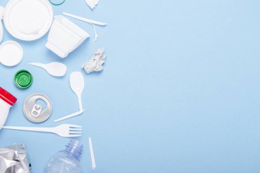 Çöp toplama, plastik ve metal mavi bir arka plan üzerinde. Kavram durdurmak plastik, geri dönüşüm, çöp ayrı toplama. Düz döşeme, üst görünüm