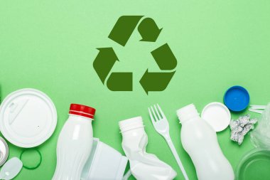 Çöp toplama, plastik ve metal yeşil bir arka plan üzerinde. Kavram durdurmak plastik, geri dönüşüm, çöp ayrı toplama. Düz döşeme, üst görünüm