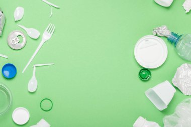 Çöp toplama, plastik ve metal yeşil bir arka plan üzerinde. Kavram durdurmak plastik, geri dönüşüm, çöp ayrı toplama. Düz döşeme, üst görünüm