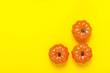 Sarı bir arka plan üzerinde dekoratif kabaklar. Cadılar Bayramı konsepti, hasat, sonbahar. Düz döşeme, üst görünüm