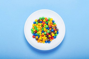 Renkli şekerler arka plan, kopya alanı. Çok renkli sır dragee fındık. Pasta dekorasyonu yayan tatlı şekerler. Renkli kaplı şeker yığını. Tatlılar doku, desen. Üst görünüm, düz yatıyordu