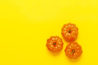 Sarı bir arka plan üzerinde dekoratif kabaklar. Cadılar Bayramı konsepti, hasat, sonbahar. Düz döşeme, üst görünüm