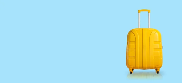 Gelber Koffer auf blauem Hintergrund. Banner. Reise- und Urlaubskonzept — Stockfoto