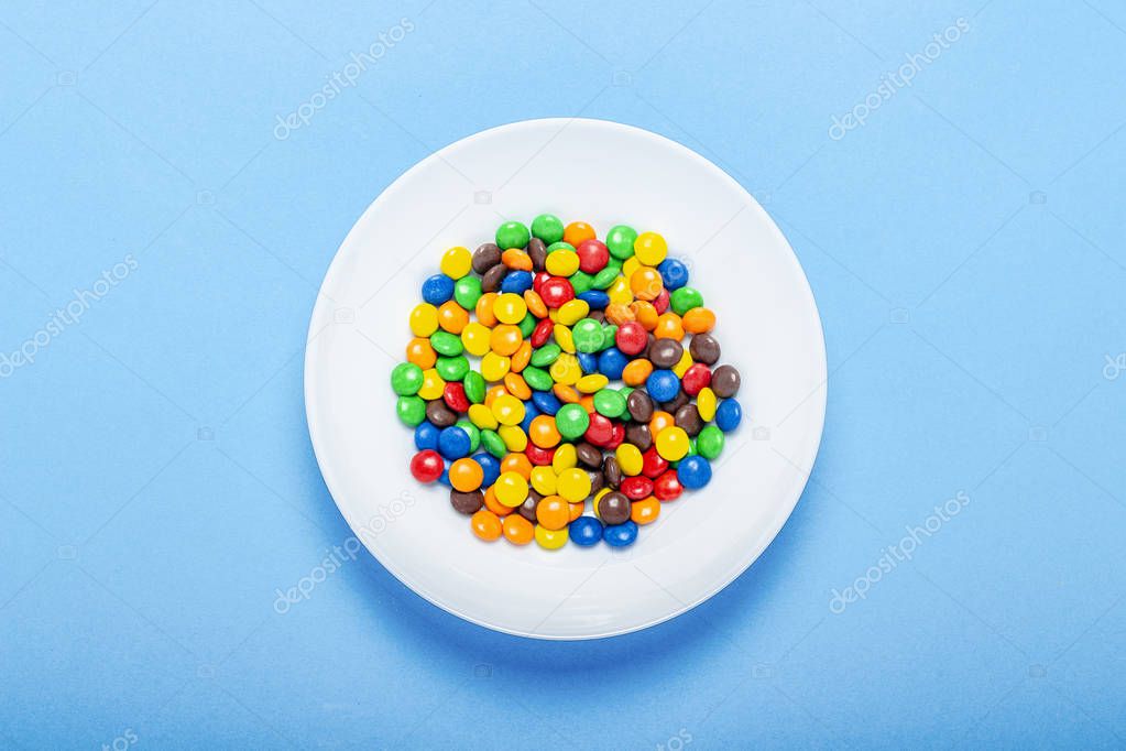 Colorful candies background, copy space. Nuts in multi-colored glaze dragee. Sweet candies spreading pastry decoration. Pile of colorful coated candy. Sweets texture, pattern. Top view, flat lay