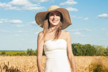 Beyaz elbiseli ve Milf 's Field' da şapkalı güzel bir kadın. Açık hava eğlencesi, köy gezisi.