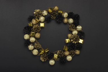 Çam kozalakları ve fındık altın, siyah, beyaz renk, Noel ağacı süslemeleri siyah bir zemin üzerine boyalı. Daire şekli. Mutlu yeni yıl ve mutlu Noeller kavramı. Düz yatıyordu, en iyi görünümü