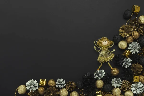 Piniové kužele a ořechy namalované ve zlatých, černých, bílých barvách, dekorace vánočních stromů na černém pozadí. Koncept šťastného nového roku a veselé Vánoce. Plochý, pohled shora — Stock fotografie