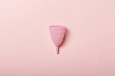 Pembe bir arka plan üzerinde adet fincan. Adet kavramı. Düz yatıyordu, üst