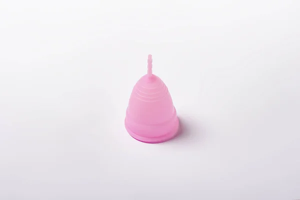 白色背景上的粉红色月经杯。月经的概念，女性卫生用品之间的选择。平铺，顶部 — 图库照片