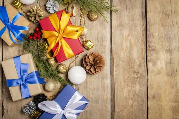 Flera presentaskar, julpynt, julgransgren på en träbakgrund. Begreppet jul, vinter semester, nytt år. Platt ligg, ovanifrån — Stockfoto