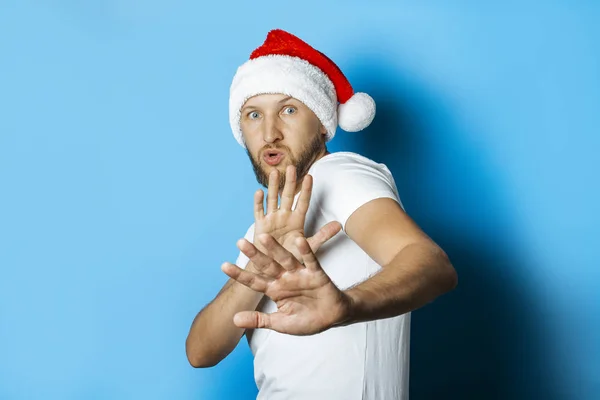 산타클로스 모자를 쓴 사람 이손으로 불쾌 한 몸짓을 한다 — 스톡 사진