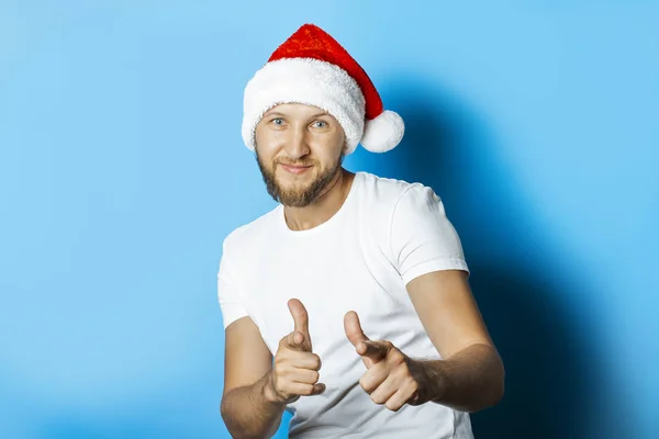 Mann mit Weihnachtsmann-Hut macht eine Geste mit den Händen auf einem Blu — Stockfoto