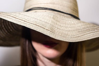 Şapkalı genç bir kadın. Yüzü örtülü şapka. Moda stüdyosu portresi