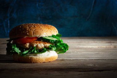 Taze iştah açıcı hamburgerle ahşap masada sığır eti..