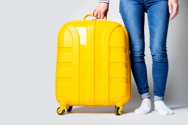 Mladá Žena Drží Žlutý Kufr Světlém Pozadí Koncept Dovolené Cestování — Stock fotografie