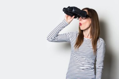 Dürbünle arka tarafı hafif arka planda olan genç ve dost canlısı kız. Pankart. Duygusal yüz..