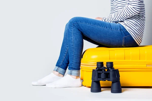 Frau Sitzt Auf Einem Gelben Plastikkoffer Und Neben Dem Fernglas — Stockfoto