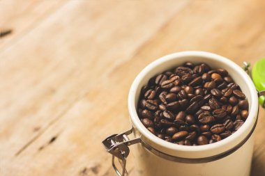 Tahta bir masanın üzerinde kahve taneleri var. Pankart. Kahve, çiftlik, işleme, koleksiyon kavramı. Üst manzara, düz uzanma.