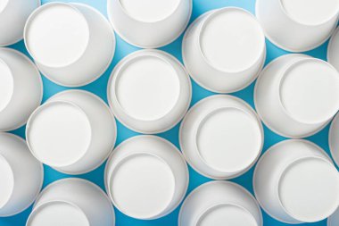 Mavi arka planda ters çevrilmiş kağıt bardaklar. Pankart. Düz yatış, üst görünüm.