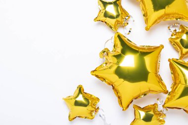 Hava altın balonları yıldız şeklinde ve beyaz arka planda şekerler. Tatil, parti, fotoğraf bölgesi, dekorasyon. Banner Düz yatar, üst görünüm.