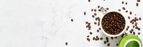 can with coffee and coffee beans scattered on a concrete background. Banner. Concept of fresh coffee, breakfast, plantation. Top view, flat lay.