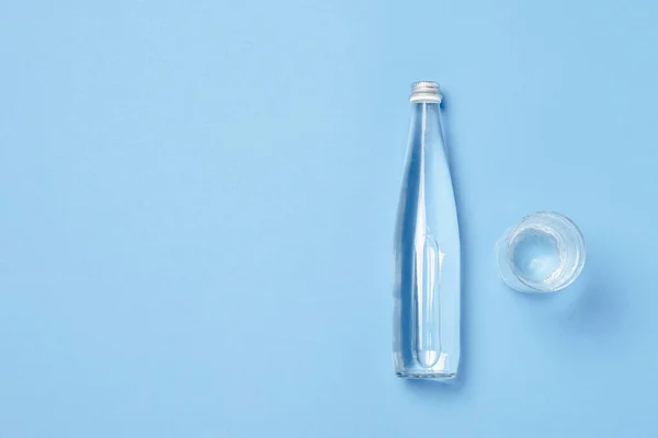Glasflasche Und Glas Mit Klarem Wasser Auf Blauem Hintergrund Konzept — Stockfoto