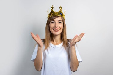 Kafasında tacı olan genç bir kadın. Duygusal kahkaha, sürpriz, öpücük. Kraliçe konsepti, şans, en iyisi, kazanmak, zafer. Pankart.