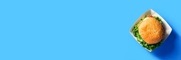 鮮やかなブルーの背景に新鮮なバーガー フラットレイアウト トップビュー バナー — ストック写真