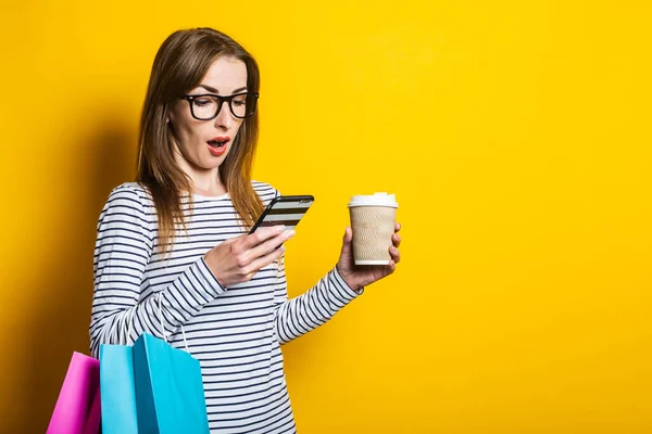 Surprised Shocked Young Woman Phone Shopping Bags Paper Cup Yellow — Stock Photo, Image