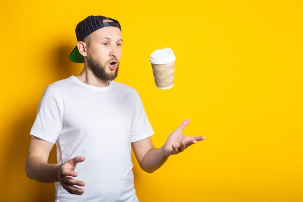 Surprised Young Guy White Shirt Catches Paper Cup Yellow Background — Stock Photo, Image