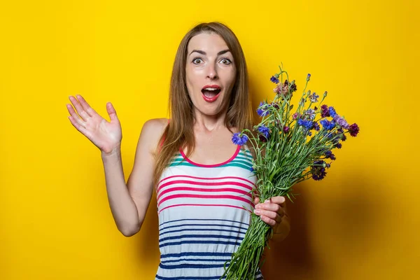 Sorprendida Joven Sorprendida Vestido Rayas Sosteniendo Flores Silvestres Sobre Fondo — Foto de Stock