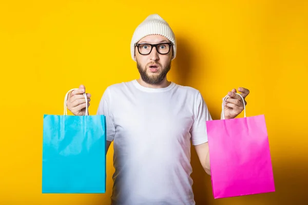 Barbudo Surpreendido Jovem Com Óculos Segurando Dois Sacos Compras Fundo — Fotografia de Stock