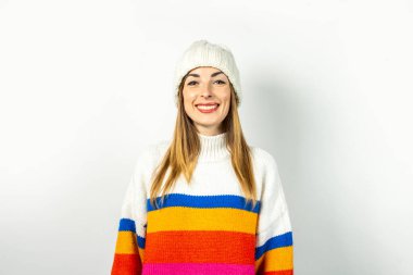Beyaz arka planda şapkası ve kazağı olan genç bir kadın. Kış, sonbahar, tarz, Noel, yeni yıl, sürpriz, şok. Pankart.