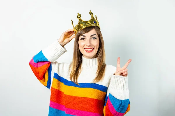 stock image Young woman with a smile in a crown and a sweater laughs on a white background. Concept of desire, planning, dream. Banner.