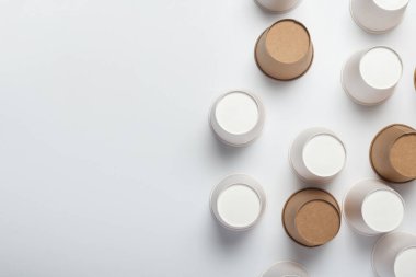 Beyaz ve kahverengi bardaklar arka planda ters çevrilmiş. Üst manzara, düz uzanma.