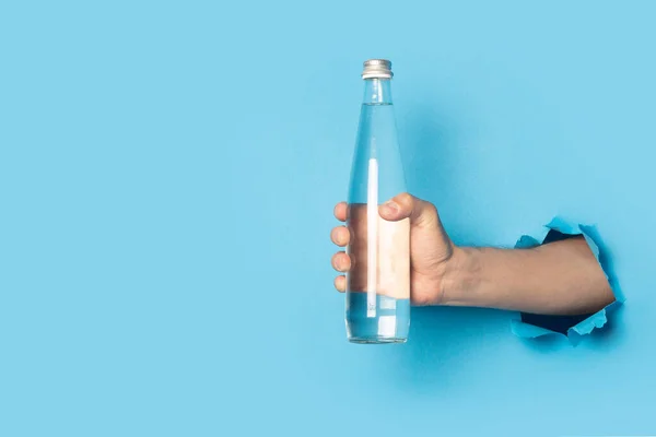 Чоловік Тримає Скляну Пляшку Водою Яскраво Синьому Фоні — стокове фото