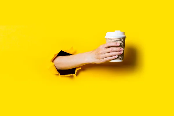 Mano Mujer Sostiene Taza Papel Con Café Sobre Fondo Amarillo — Foto de Stock