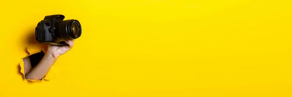 Mano Femenina Sosteniendo Una Cámara Sobre Fondo Amarillo Brillante Banner — Foto de Stock