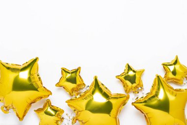 Hava altın balonları yıldız şeklinde ve beyaz arka planda şekerler. Tatil, parti, fotoğraf bölgesi, dekorasyon. Banner Düz yatar, üst görünüm.