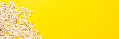 Sarı arka planda patlamış mısır. Kavram serisi, film, spor. Pankart. Düz yatış, üst görünüm.