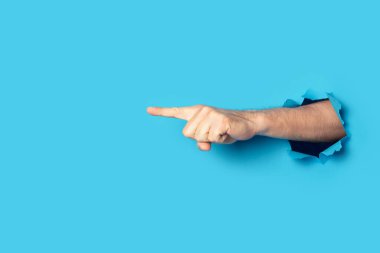 El, mavi arka planda bir şeye işaret ediyor. Şuna bak, dikkat et..