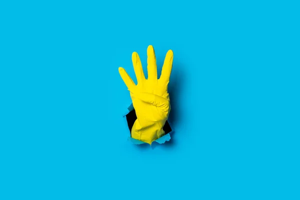 Mano Guante Amarillo Muestra Cuatro Dedos Sobre Fondo Azul Brillante — Foto de Stock