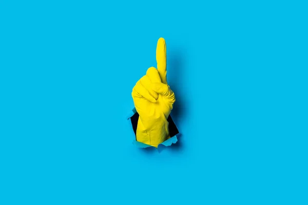 Mano Guante Amarillo Señala Dedo Sobre Fondo Azul Brillante — Foto de Stock